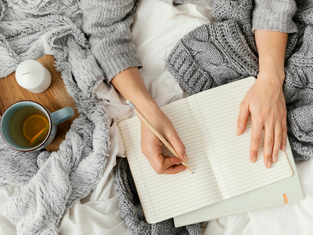 woman writing in a notebook with just her hands showing