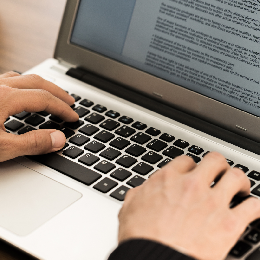 A person typing on a laptop, symbolizing the digital marketing solutions provided through the service packages for authors.