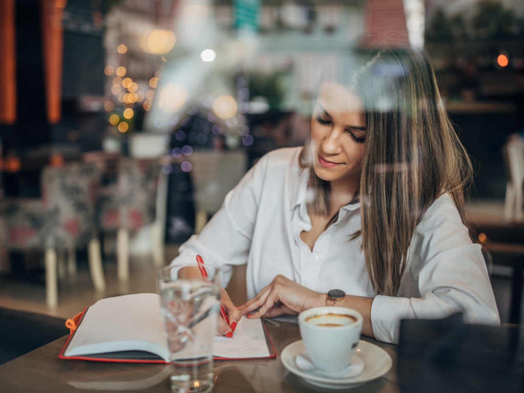 female author writing in a cafe